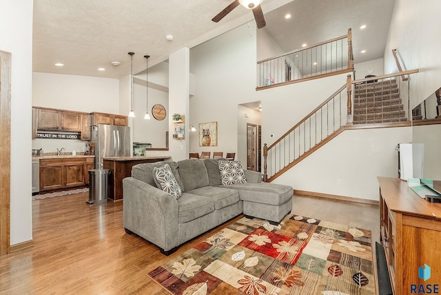 4005 S Grand Slam Ave, Sioux Falls, SD 57110 - living room with stairway, light wood-style floors, ceiling fan, high vaulted ceiling, and recessed lighting