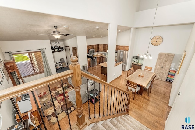 4005 S Grand Slam Ave, Sioux Falls, SD 57110 - staircase with wood finished floors, a chandelier, a ceiling fan, and a high ceiling