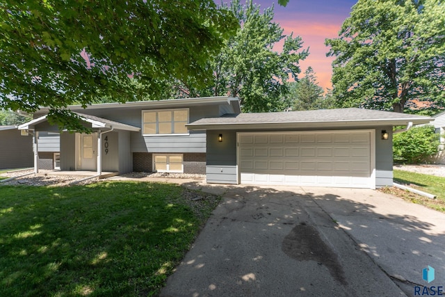 409 S 8th Ave, Brandon, SD 57005 - tri-level home featuring concrete driveway, an attached garage, brick siding, and a lawn