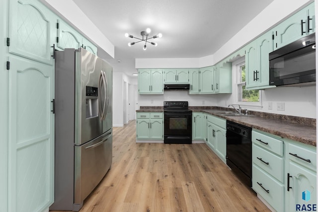 409 S 8th Ave, Brandon, SD 57005 - kitchen featuring black appliances, under cabinet range hood, dark countertops, light wood finished floors, and a chandelier