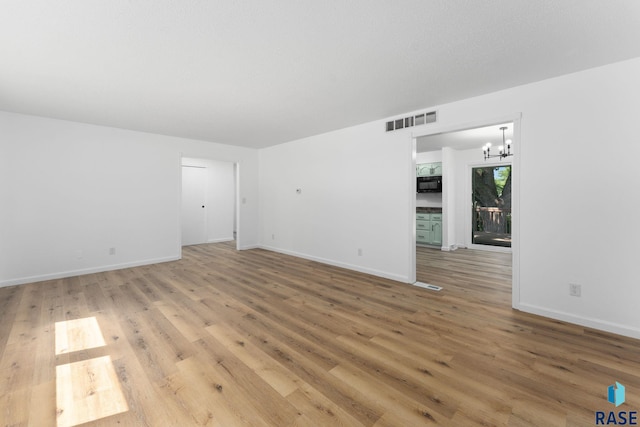 409 S 8th Ave, Brandon, SD 57005 - spare room with a chandelier and light wood finished floors