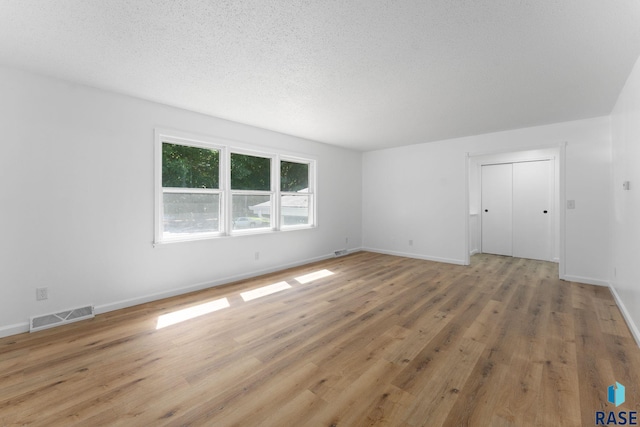 409 S 8th Ave, Brandon, SD 57005 - unfurnished living room with light wood-style floors and a textured ceiling