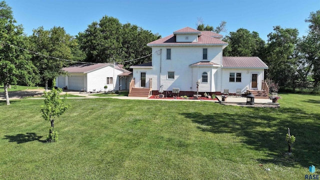 28437 462nd Ave, Davis, SD 57021 - view of front of property with a metal roof, a front yard, entry steps, an outbuilding, and a garage