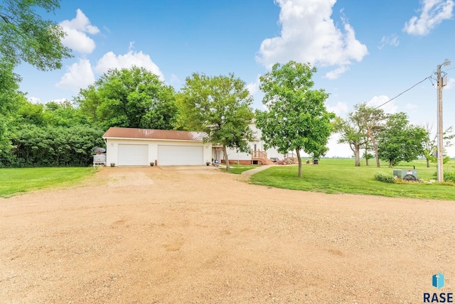 28437 462nd Ave, Davis, SD 57021 - view of front facade featuring driveway, a front yard, an outbuilding, and stucco siding