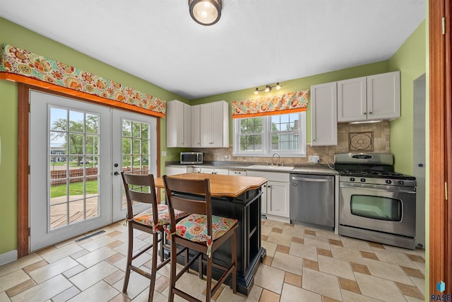 624 S 2nd Ave, Sioux Falls, SD 57104 - kitchen with stainless steel appliances, white cabinetry, decorative backsplash, and french doors