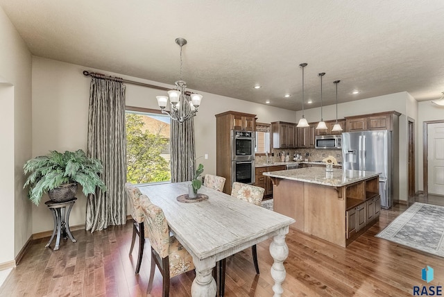 5809 S Nature Run Pl, Sioux Falls, SD 57108 - dining space featuring wood finished floors, recessed lighting, a chandelier, and a textured ceiling
