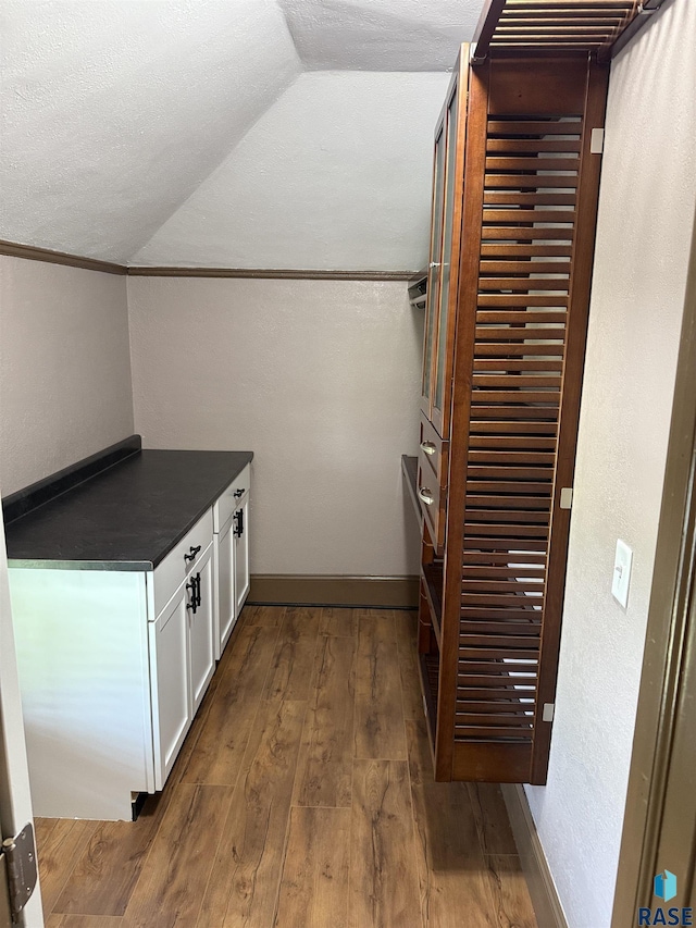 27139 US Highway 81, Freeman, SD 57319 - bar area with vaulted ceiling, dark wood-style floors, a textured wall, and a textured ceiling