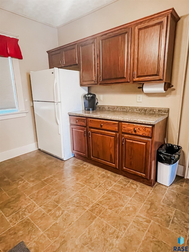 402 E 1st Ave, Beaver Creek, MN 56116 - kitchen with freestanding refrigerator, brown cabinetry, and light countertops