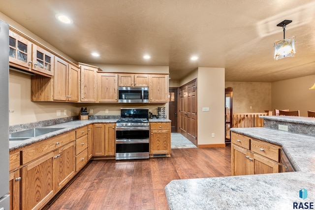 705 Railway St, Canistota, SD 57012 - kitchen with stainless steel appliances, dark wood finished floors, recessed lighting, glass insert cabinets, and pendant lighting