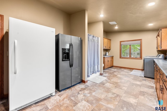 705 Railway St, Canistota, SD 57012 - kitchen with stainless steel fridge with ice dispenser, freestanding refrigerator, washing machine and dryer, recessed lighting, and light stone finish floors
