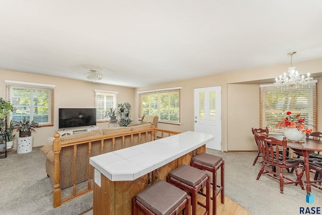 612 E 26th St, Sioux Falls, SD 57105 - kitchen with tile countertops, a chandelier, a center island, and healthy amount of natural light