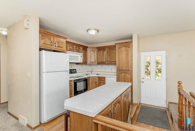 612 E 26th St, Sioux Falls, SD 57105 - kitchen featuring white appliances, tile countertops, and brown cabinetry