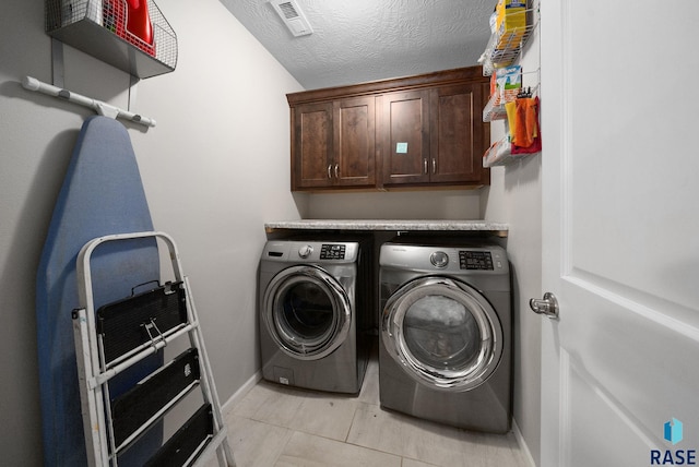 601 W Highpointe St, Tea, SD 57064 - laundry room with washer and dryer, light tile patterned flooring, a textured ceiling, and cabinet space