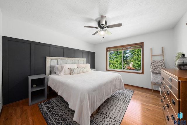 1413 Holbrook Ave, Sioux Falls, SD 57107 - bedroom with light wood-style floors, ceiling fan, a decorative wall, and a textured ceiling
