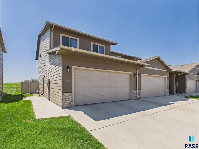 2560 E Meadowside Pl, Sioux Falls, SD 57108 - view of front of property featuring stone siding, driveway, and a front lawn
