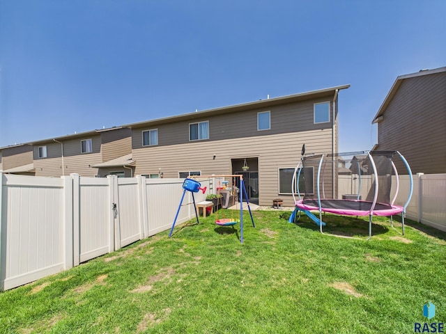 2560 E Meadowside Pl, Sioux Falls, SD 57108 - rear view of property with a trampoline and a fenced backyard