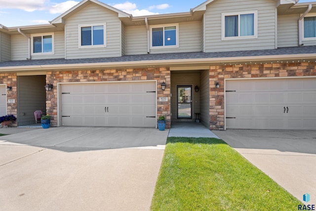 9232 W Norma Trl Unit 2, Sioux Falls, SD 57106 - view of property with a garage, driveway, and stone siding