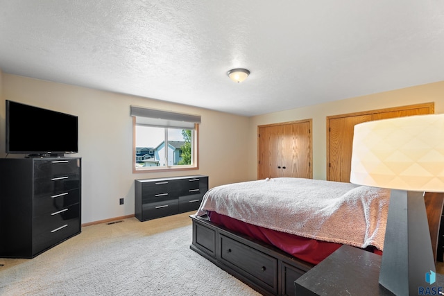9232 W Norma Trl Unit 2, Sioux Falls, SD 57106 - bedroom featuring light carpet, multiple closets, and a textured ceiling