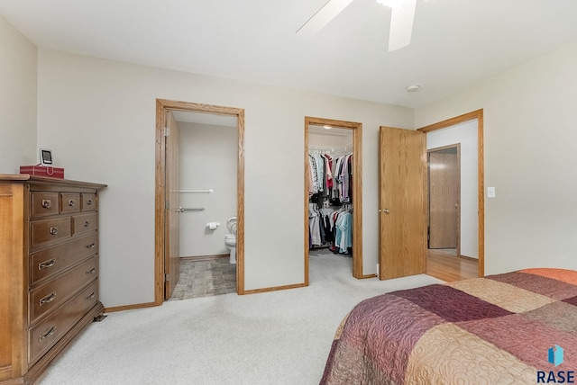 303 E 11th St, Dell Rapids, SD 57022 - bedroom featuring a spacious closet, light colored carpet, a closet, connected bathroom, and ceiling fan
