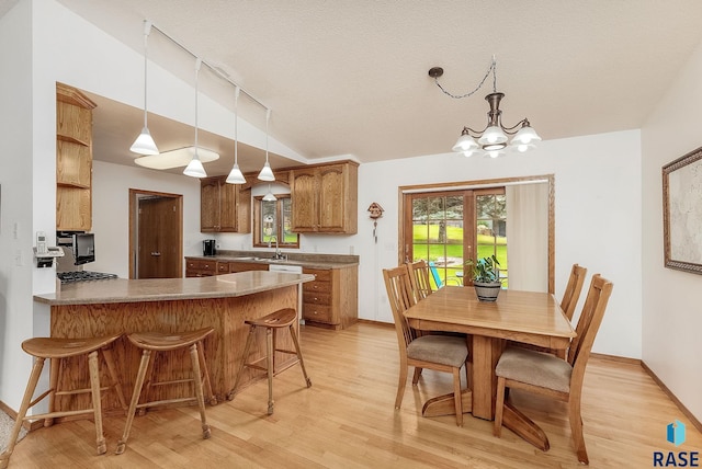 303 E 11th St, Dell Rapids, SD 57022 - kitchen featuring light wood-style floors, a chandelier, a peninsula, pendant lighting, and a breakfast bar