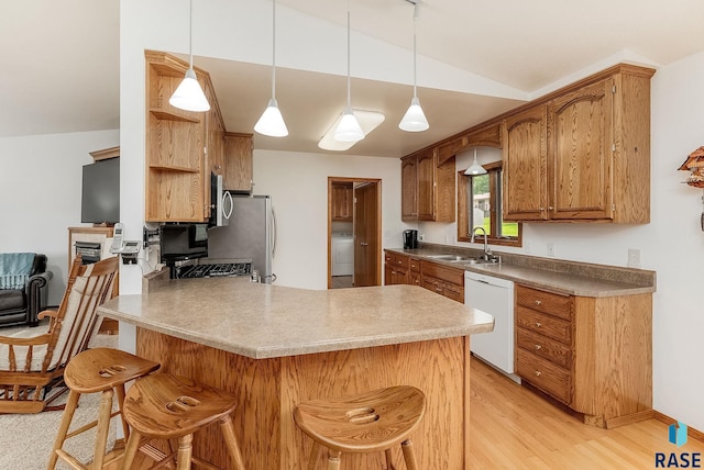303 E 11th St, Dell Rapids, SD 57022 - kitchen with appliances with stainless steel finishes, a peninsula, vaulted ceiling, washer / dryer, and a breakfast bar