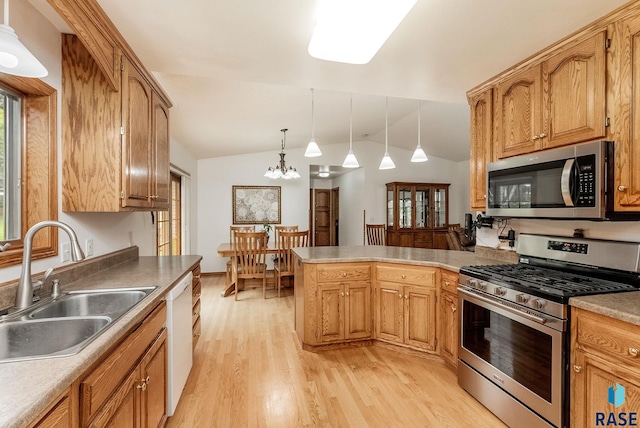 303 E 11th St, Dell Rapids, SD 57022 - kitchen featuring appliances with stainless steel finishes, light wood finished floors, lofted ceiling, a peninsula, and hanging light fixtures