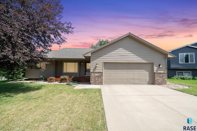 6045 W Jordan Ct, Sioux Falls, SD 57106 - view of front of home with brick siding, an attached garage, concrete driveway, and a lawn