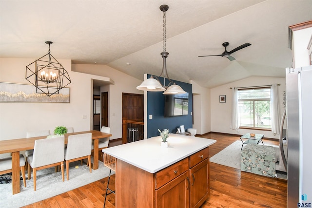 3208 S Triple Play Ave, Sioux Falls, SD 57110 - kitchen with freestanding refrigerator, vaulted ceiling, a chandelier, wood finished floors, and a center island