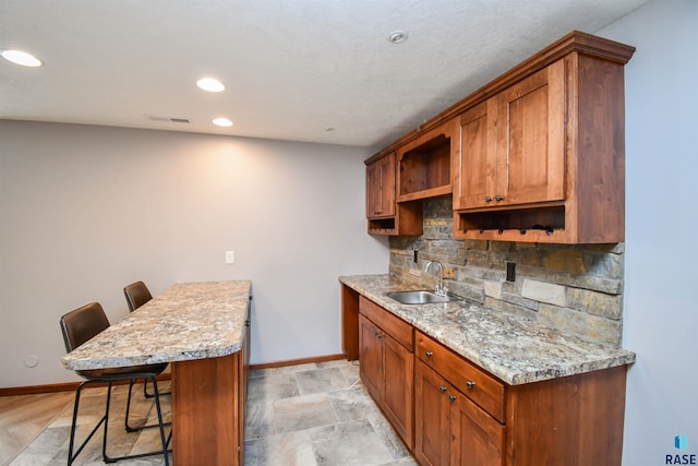 3208 S Triple Play Ave, Sioux Falls, SD 57110 - kitchen with a peninsula, a kitchen bar, brown cabinets, open shelves, and recessed lighting