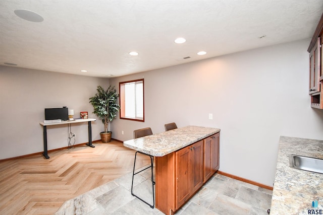 3208 S Triple Play Ave, Sioux Falls, SD 57110 - kitchen with a peninsula, an office area, a breakfast bar, brown cabinets, and recessed lighting