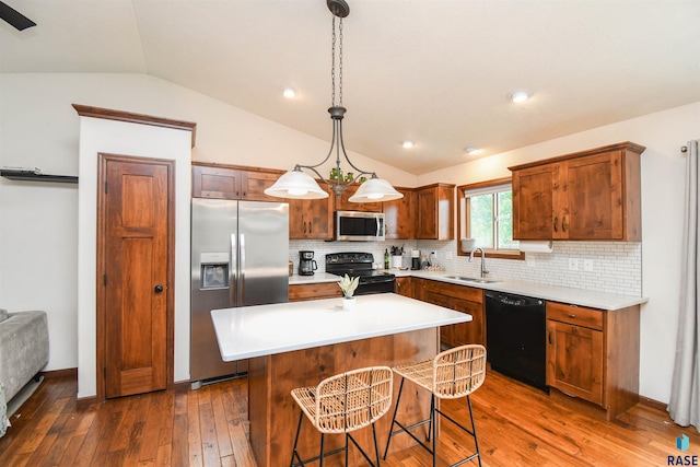 3208 S Triple Play Ave, Sioux Falls, SD 57110 - kitchen featuring black appliances, lofted ceiling, hardwood / wood-style flooring, a center island, and a kitchen breakfast bar