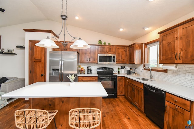 3208 S Triple Play Ave, Sioux Falls, SD 57110 - kitchen featuring black appliances, vaulted ceiling, dark wood-type flooring, a breakfast bar area, and tasteful backsplash