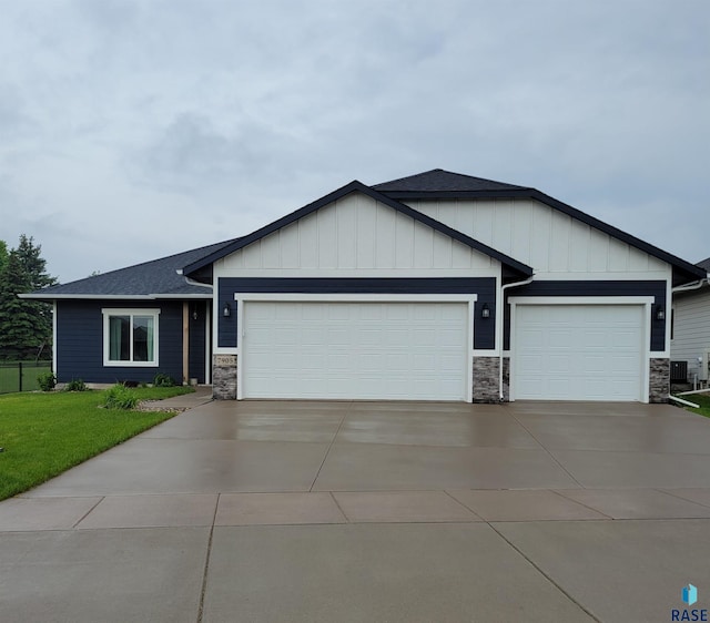 7905 S Brande Park Cir, Sioux Falls, SD 57108 - view of front facade with stone siding, a garage, concrete driveway, and board and batten siding