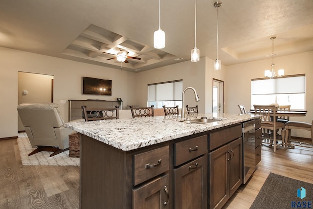 7905 S Brande Park Cir, Sioux Falls, SD 57108 - kitchen with coffered ceiling, light wood finished floors, dark brown cabinetry, a tray ceiling, and light stone counters