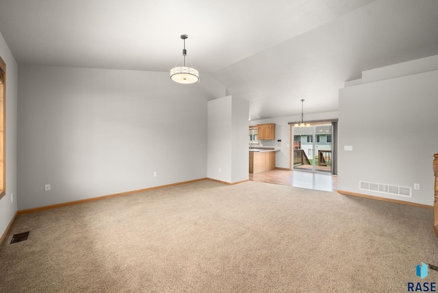 7020 W 53rd St, Sioux Falls, SD 57106 - unfurnished living room with light carpet, vaulted ceiling, and a chandelier