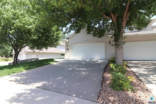 5708 S Shadow Wood Pl, Sioux Falls, SD 57108 - view of property hidden behind natural elements with concrete driveway and stucco siding