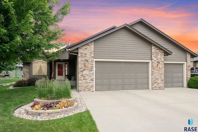 4912 E 42nd St, Sioux Falls, SD 57110 - view of front facade with a garage, brick siding, driveway, and a front yard