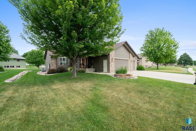 4912 E 42nd St, Sioux Falls, SD 57110 - view of property hidden behind natural elements featuring driveway, stone siding, a garage, and a front yard
