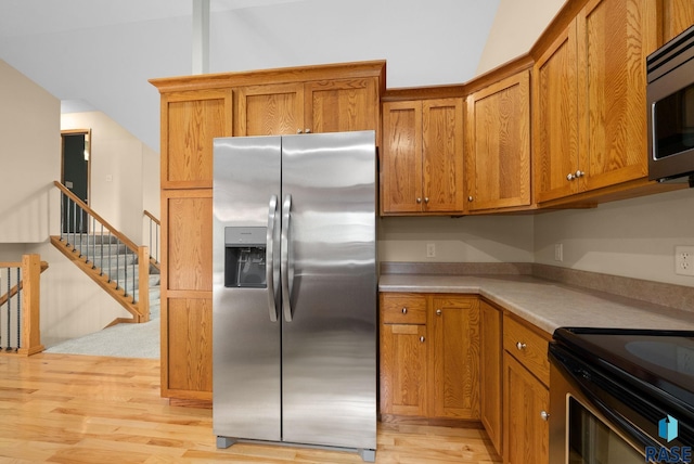 4912 E 42nd St, Sioux Falls, SD 57110 - kitchen featuring stainless steel appliances, brown cabinets, light countertops, and vaulted ceiling