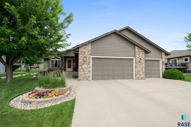 4912 E 42nd St, Sioux Falls, SD 57110 - view of front of property featuring an attached garage, concrete driveway, a front yard, and brick siding