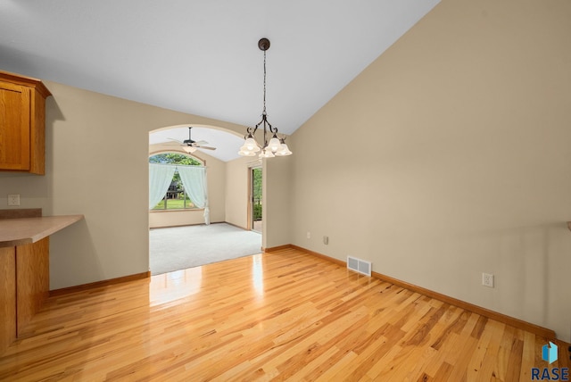 4912 E 42nd St, Sioux Falls, SD 57110 - unfurnished dining area featuring light wood-style floors, a chandelier, vaulted ceiling, ceiling fan, and arched walkways