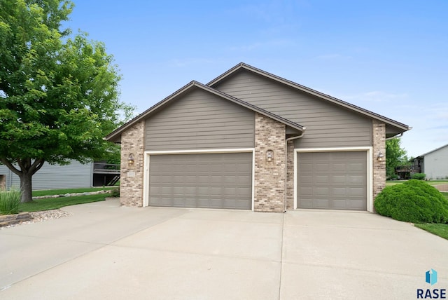 4912 E 42nd St, Sioux Falls, SD 57110 - view of front of home with concrete driveway, an attached garage, and brick siding