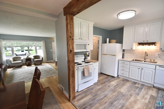1620 S W Ave, Sioux Falls, SD 57105 - kitchen featuring white appliances, light wood finished floors, backsplash, open floor plan, and white cabinetry