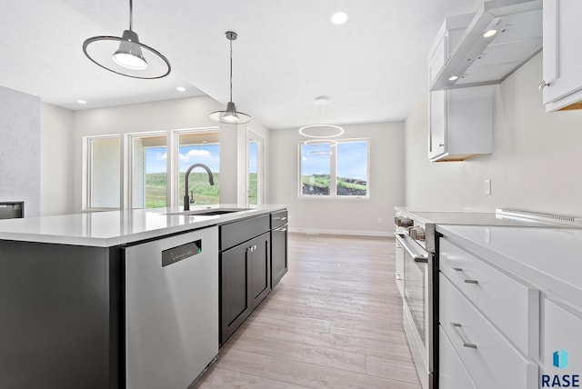 501 N Wildcat Dr, Sioux Falls, SD 57110 - kitchen featuring appliances with stainless steel finishes, wall chimney range hood, light countertops, white cabinetry, and recessed lighting