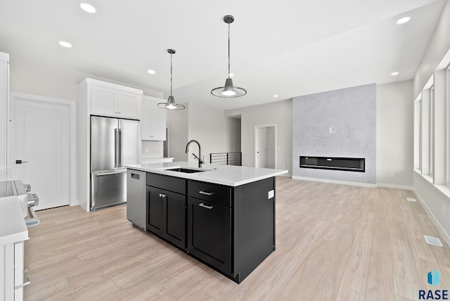 501 N Wildcat Dr, Sioux Falls, SD 57110 - kitchen with appliances with stainless steel finishes, dark cabinetry, white cabinets, light wood-style flooring, and recessed lighting