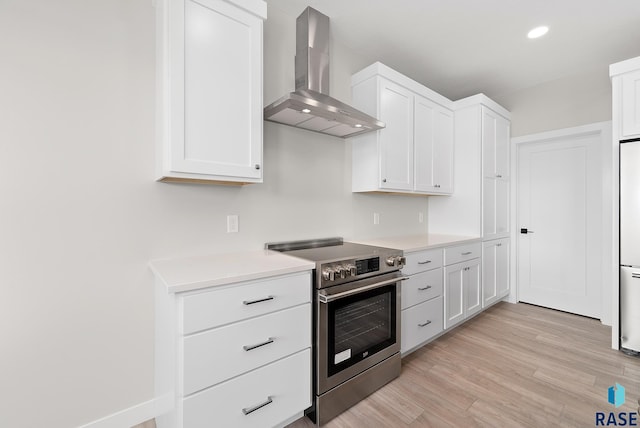 501 N Wildcat Dr, Sioux Falls, SD 57110 - kitchen with wall chimney range hood, stainless steel electric stove, light countertops, white cabinets, and recessed lighting