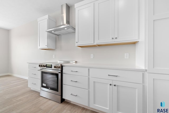 501 N Wildcat Dr, Sioux Falls, SD 57110 - kitchen with wall chimney exhaust hood, stainless steel electric range oven, light wood finished floors, light countertops, and white cabinets