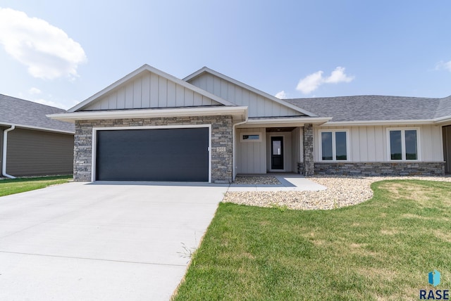 501 N Wildcat Dr, Sioux Falls, SD 57110 - view of front of property featuring stone siding, a garage, concrete driveway, a front yard, and board and batten siding
