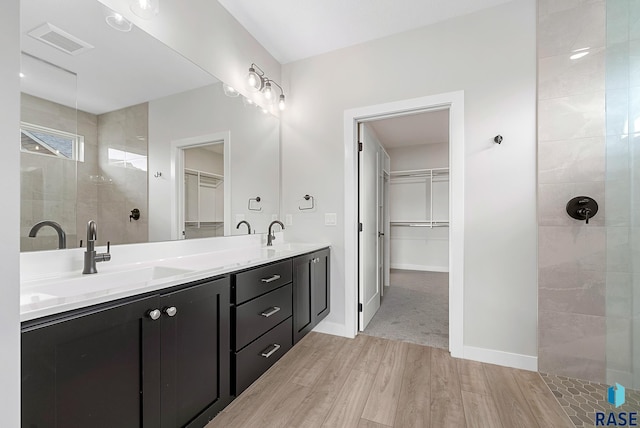 501 N Wildcat Dr, Sioux Falls, SD 57110 - bathroom featuring wood finished floors, a walk in closet, double vanity, and walk in shower