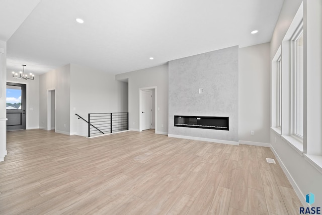 501 N Wildcat Dr, Sioux Falls, SD 57110 - unfurnished living room featuring light wood-style floors, a chandelier, a large fireplace, and recessed lighting